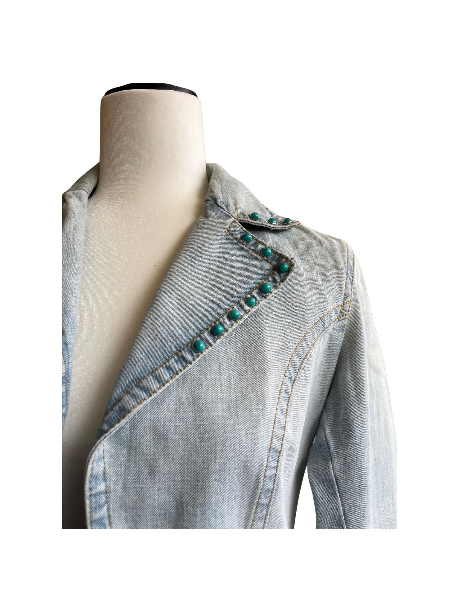 Chaqueta Bruma en denim claro, con flores bordadas sobre tul, tachuelas y encaje antiguo cosido a mano en la espalda.