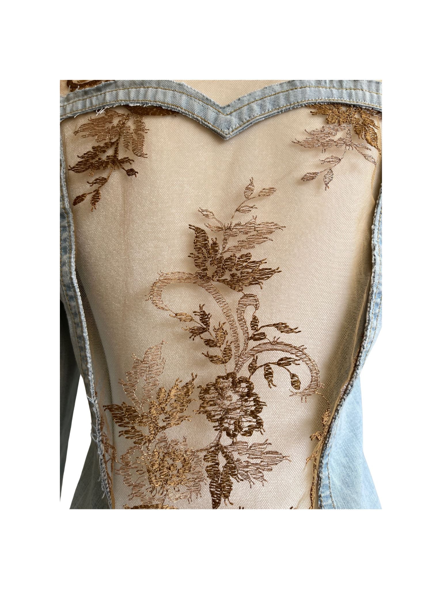 Chaqueta Bruma en denim claro, con flores bordadas sobre tul, tachuelas y encaje antiguo cosido a mano en la espalda.