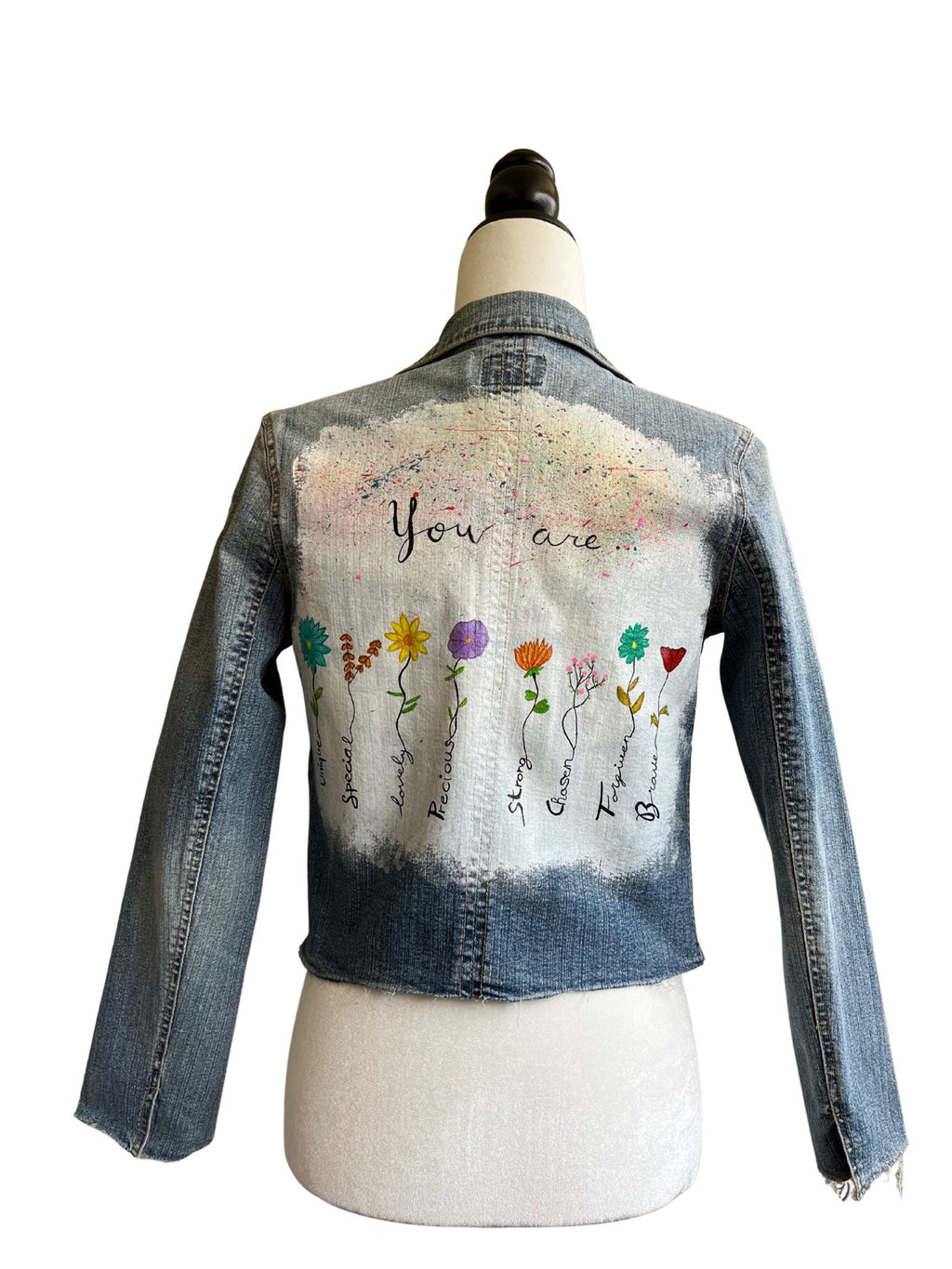 Chaqueta vaquera Lira con pintura a mano alzada en la espalda, apliques florales bordados en el frente y bolsillos restaurados con tela estampada.