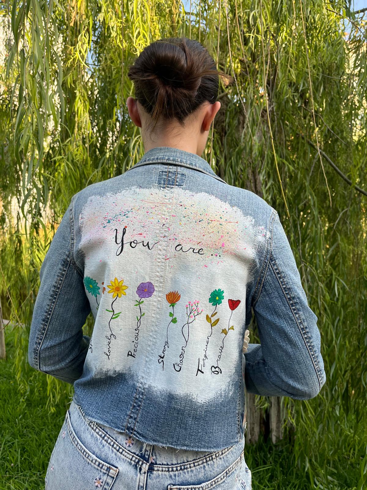 Chaqueta vaquera Lira con pintura a mano alzada en la espalda, apliques florales bordados en el frente y bolsillos restaurados con tela estampada.
