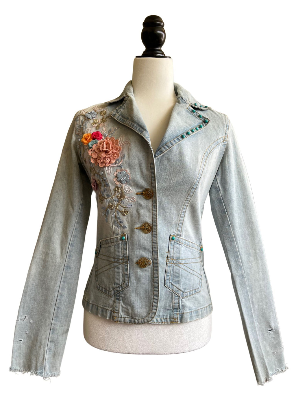 Chaqueta Bruma en denim claro, con flores bordadas sobre tul, tachuelas y encaje antiguo cosido a mano en la espalda.
