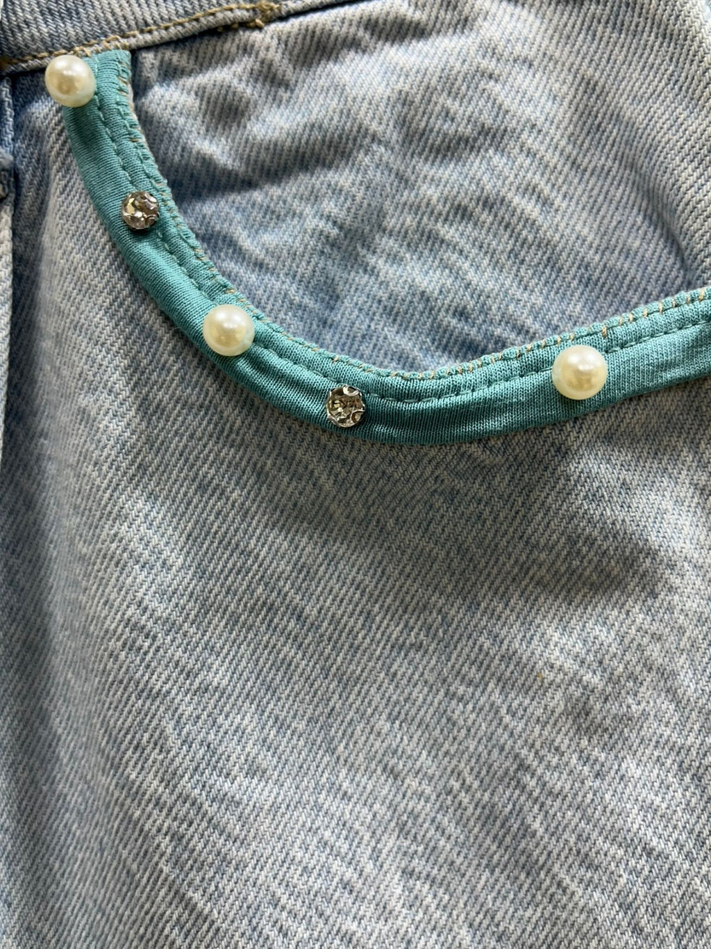 “Falda Hilena detalles de denim reciclado con pedrería, frase pintada a mano y parche de lentejuelas reversibles.”