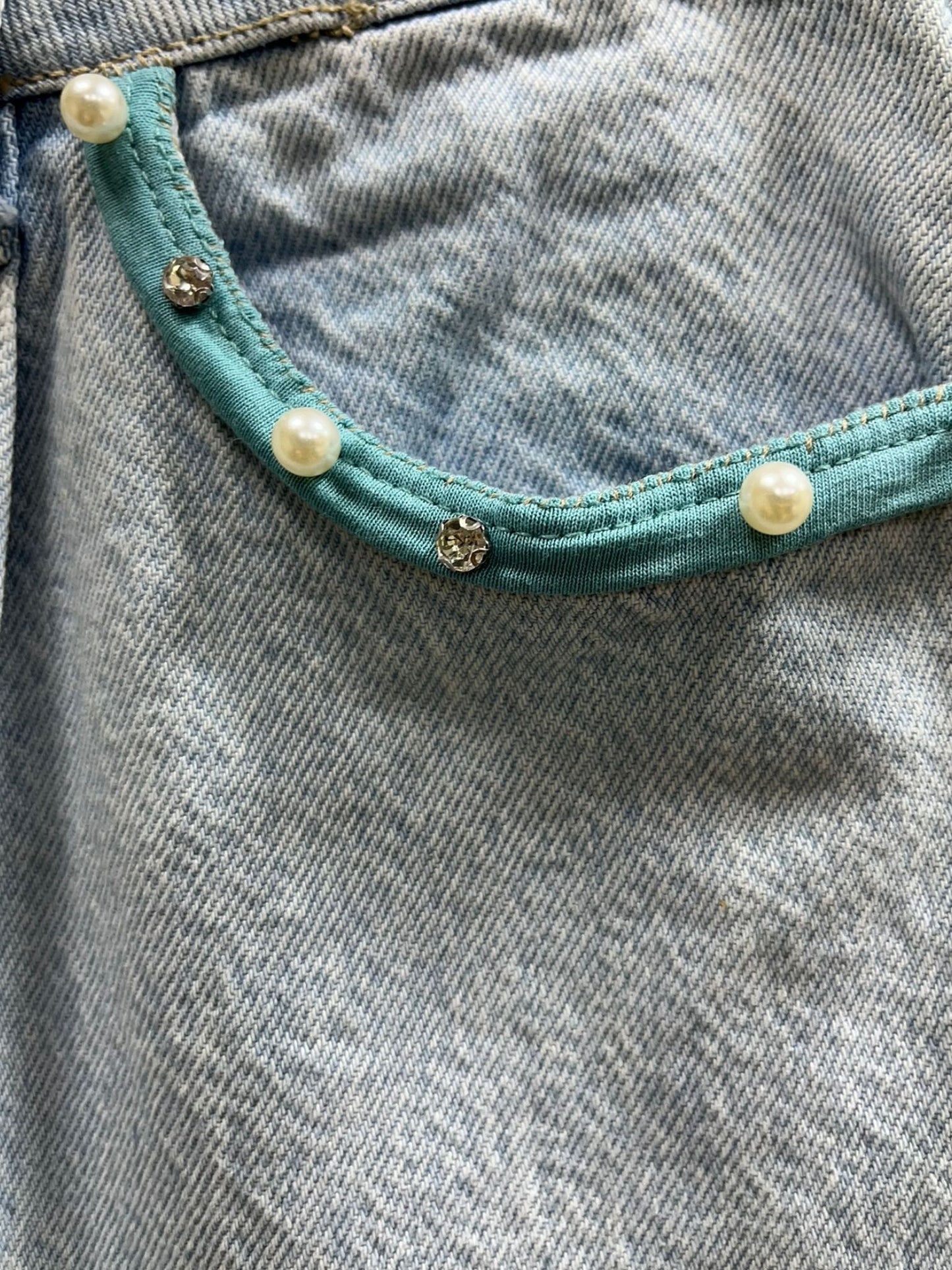 “Falda Hilena detalles de denim reciclado con pedrería, frase pintada a mano y parche de lentejuelas reversibles.”