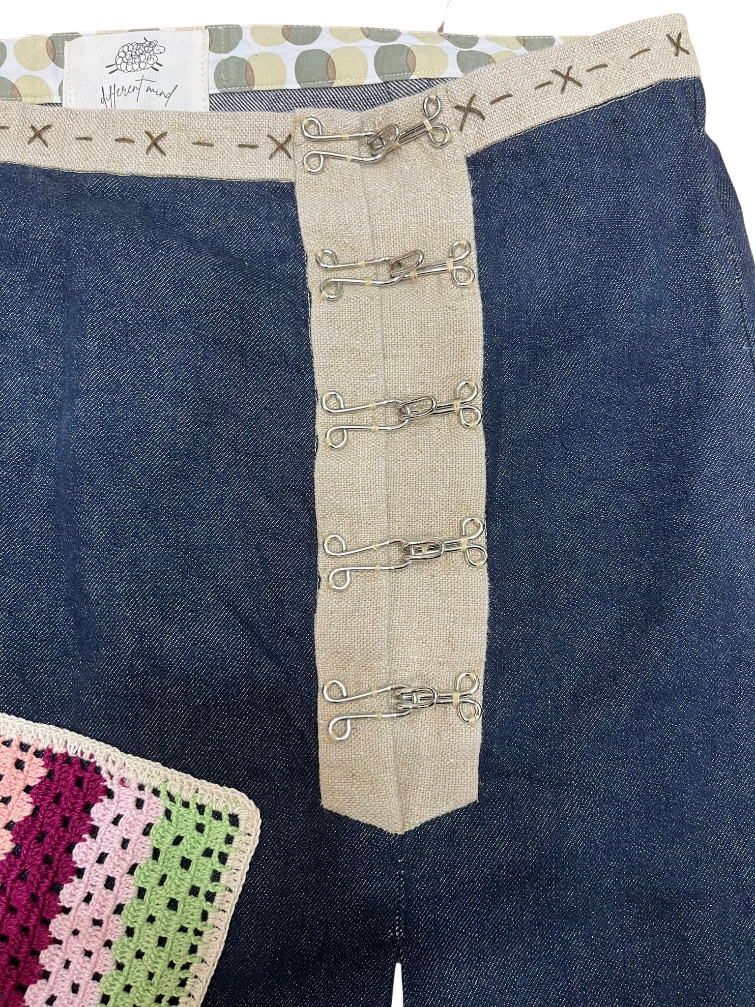 Falda Miralys artesanal en denim y lino, con parches de ganchillo, fotografiada de-frente.