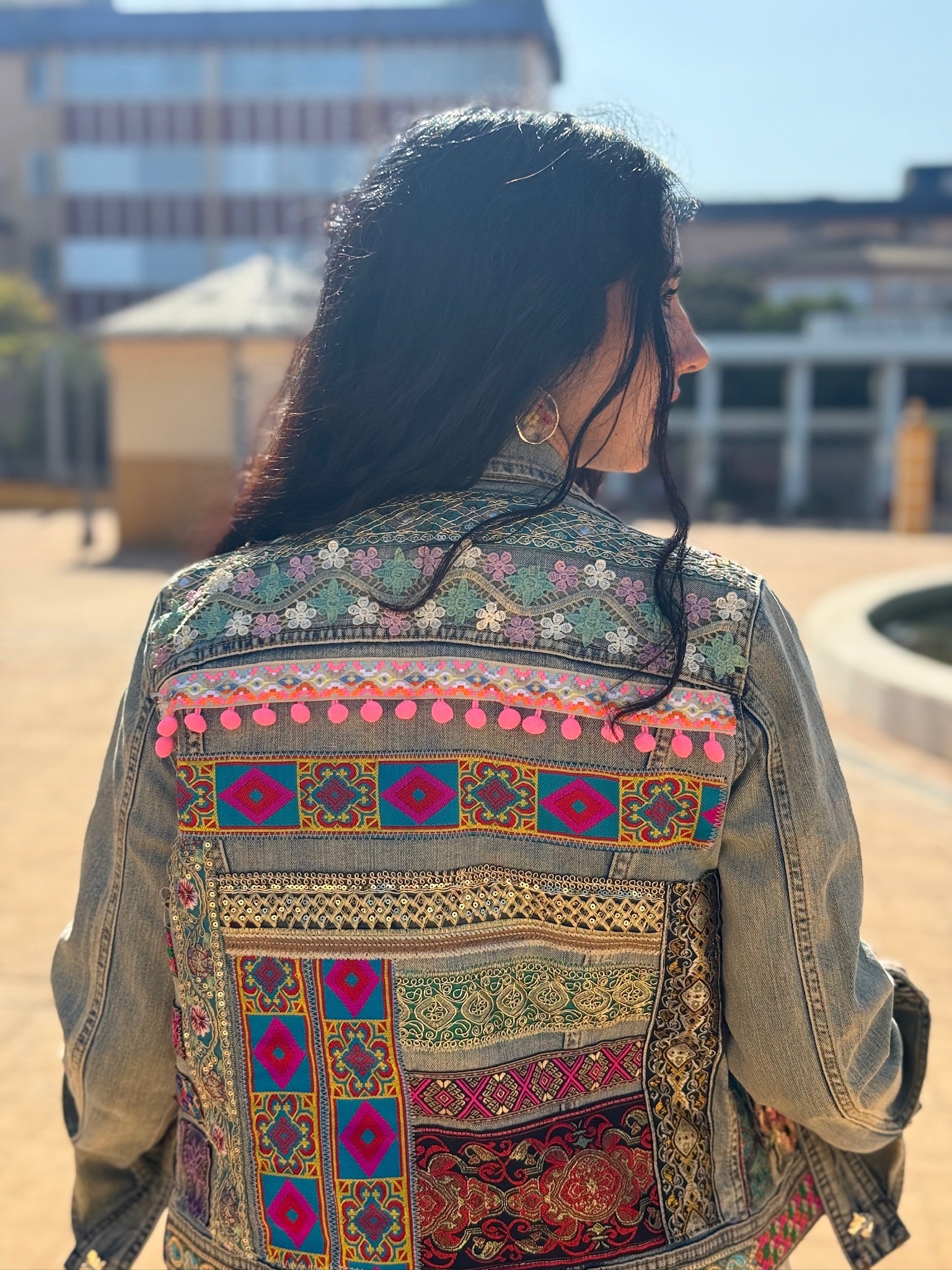 Chaqueta Zyra denim reciclado con gran patchwork de telas vintage, bordados y pompones en la espalda – pieza única hecha a mano
