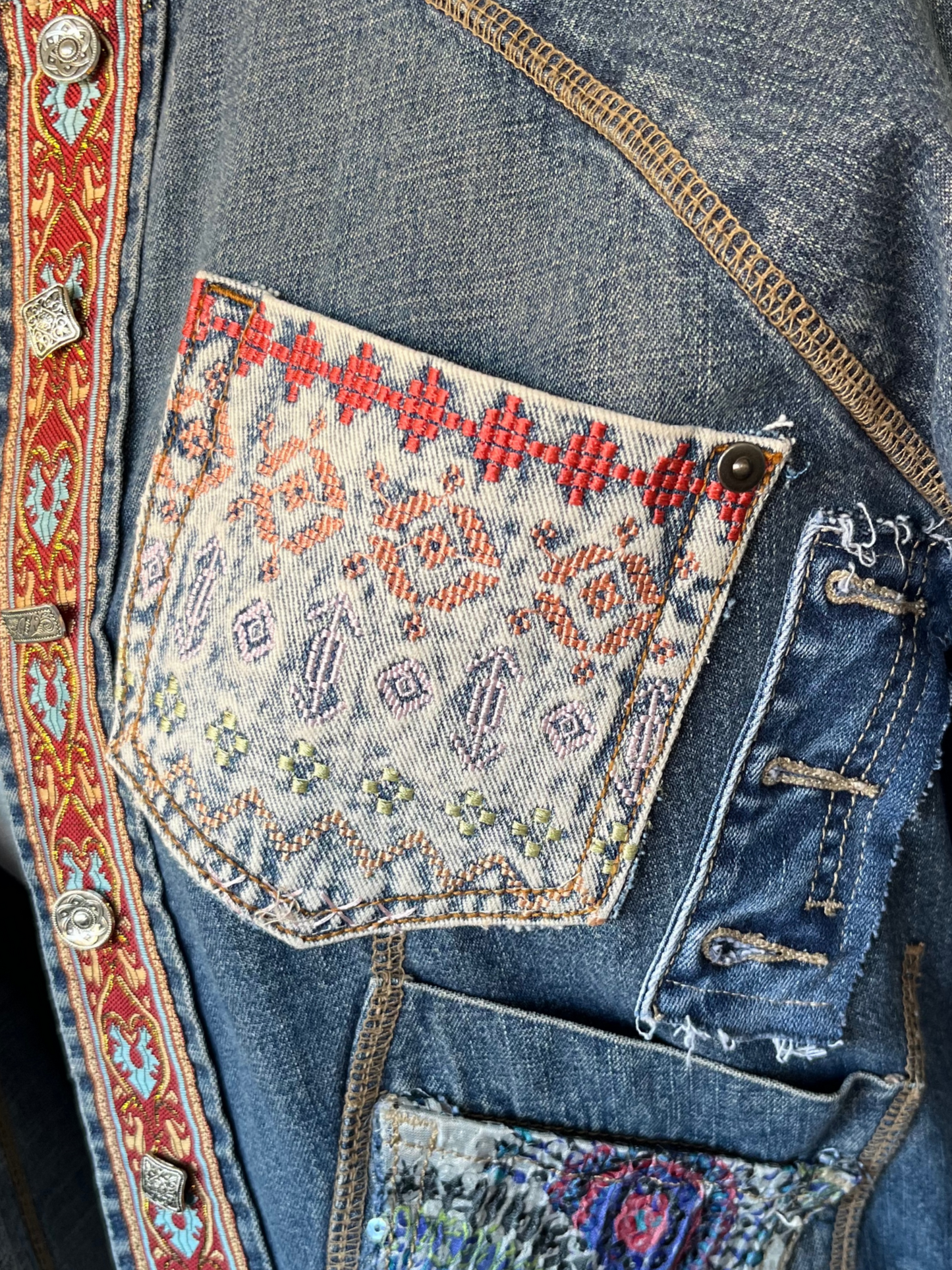 Chaqueta kalia de denim reciclado con bolsillos coloridos, cintas decorativas y cuello tachonado con botones de nácar