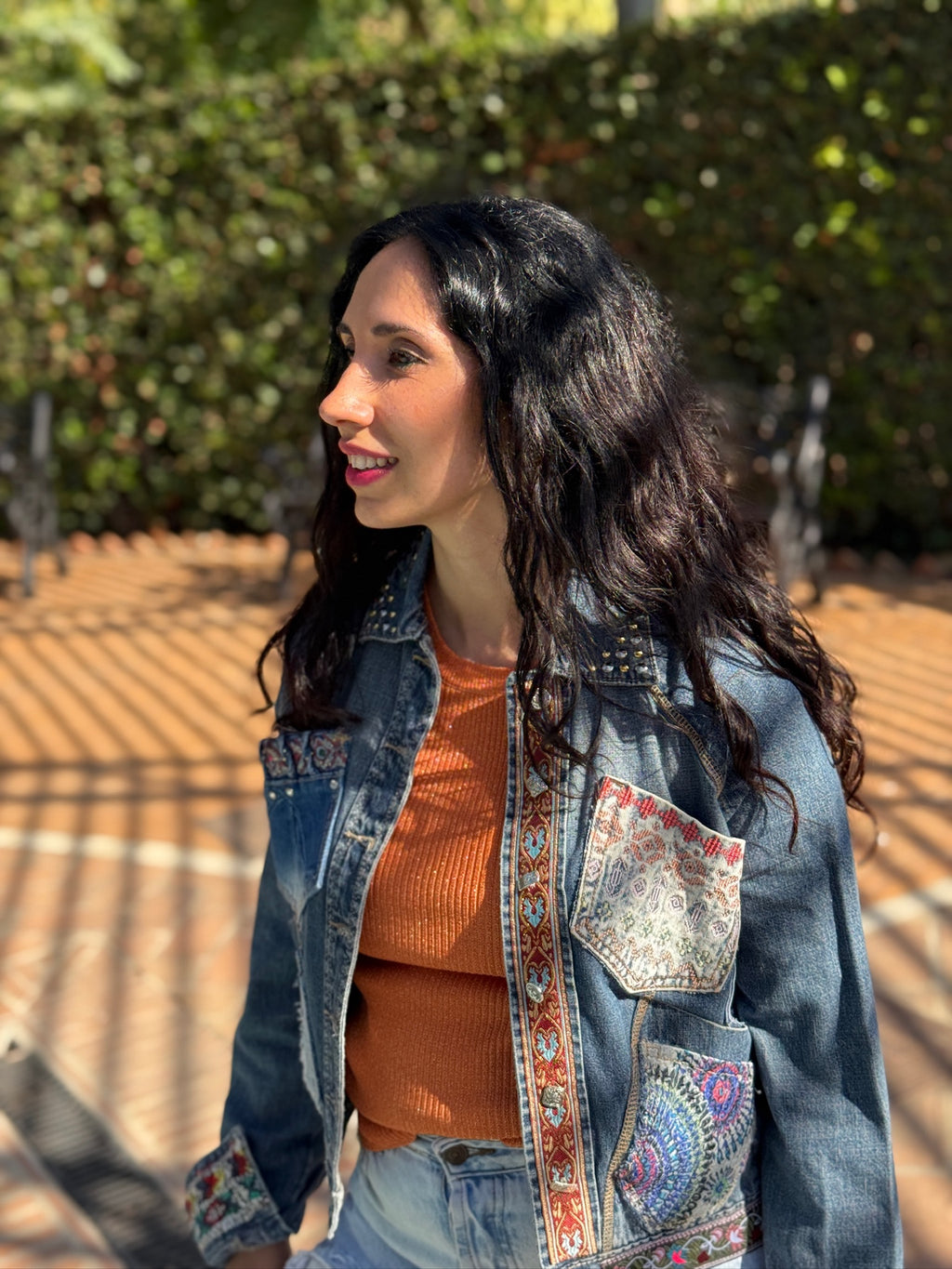 Chaqueta kalia de denim reciclado con bolsillos coloridos, cintas decorativas y cuello tachonado con botones de nácar