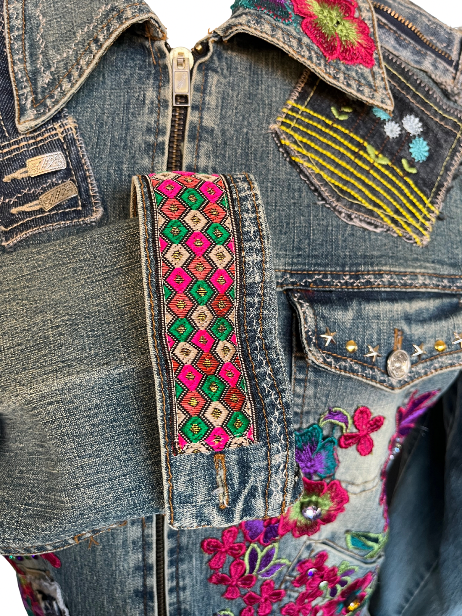Chaqueta Noira de denim reciclado con flores bordadas a mano, cremalleras, bolsillos y puños recuperados